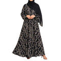 Pebble Muse Abaya with a black base, beige scattered spot print, and flowing full-length silhouette