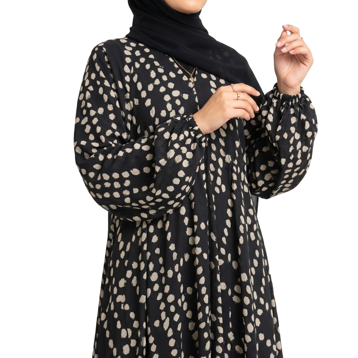 Pebble Muse Abaya with a black base, beige scattered spot print, and flowing full-length silhouette with front open 