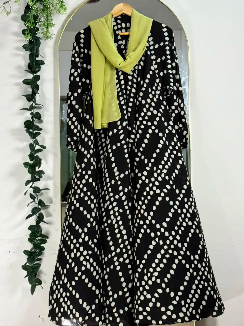 Pebble Muse Abaya with a black base, beige scattered spot print, and flowing full-length silhouette with front open 
